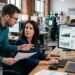 Operations manager and analyst checking an AI-generated business intelligence summary against sales dashboard figures.